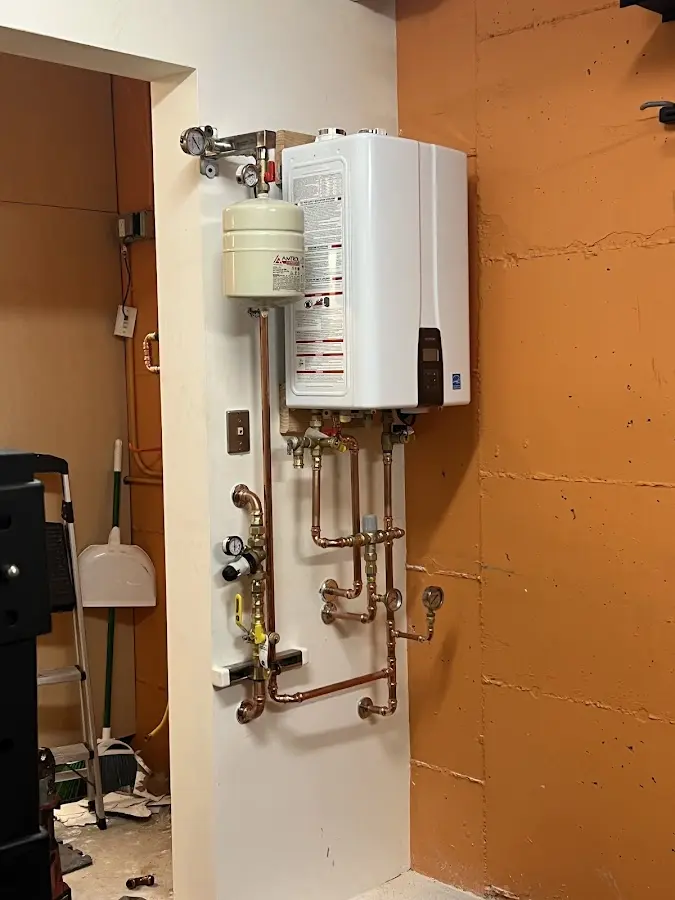 Plumbing technician inspecting water heater connections in Roselle Park